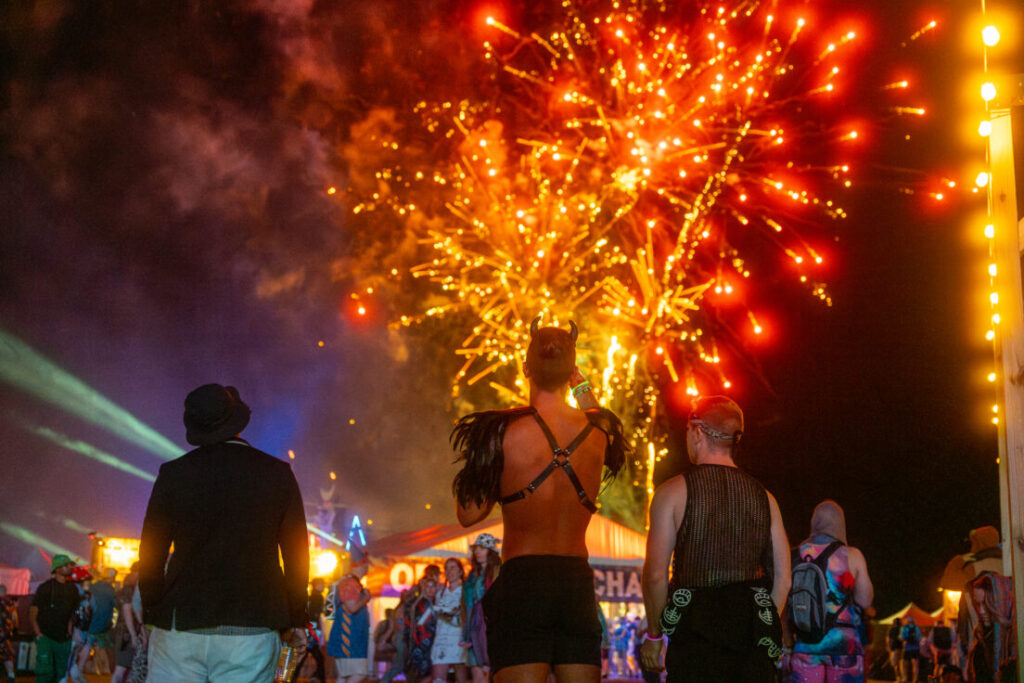 People looking at fireworks on festival grounds